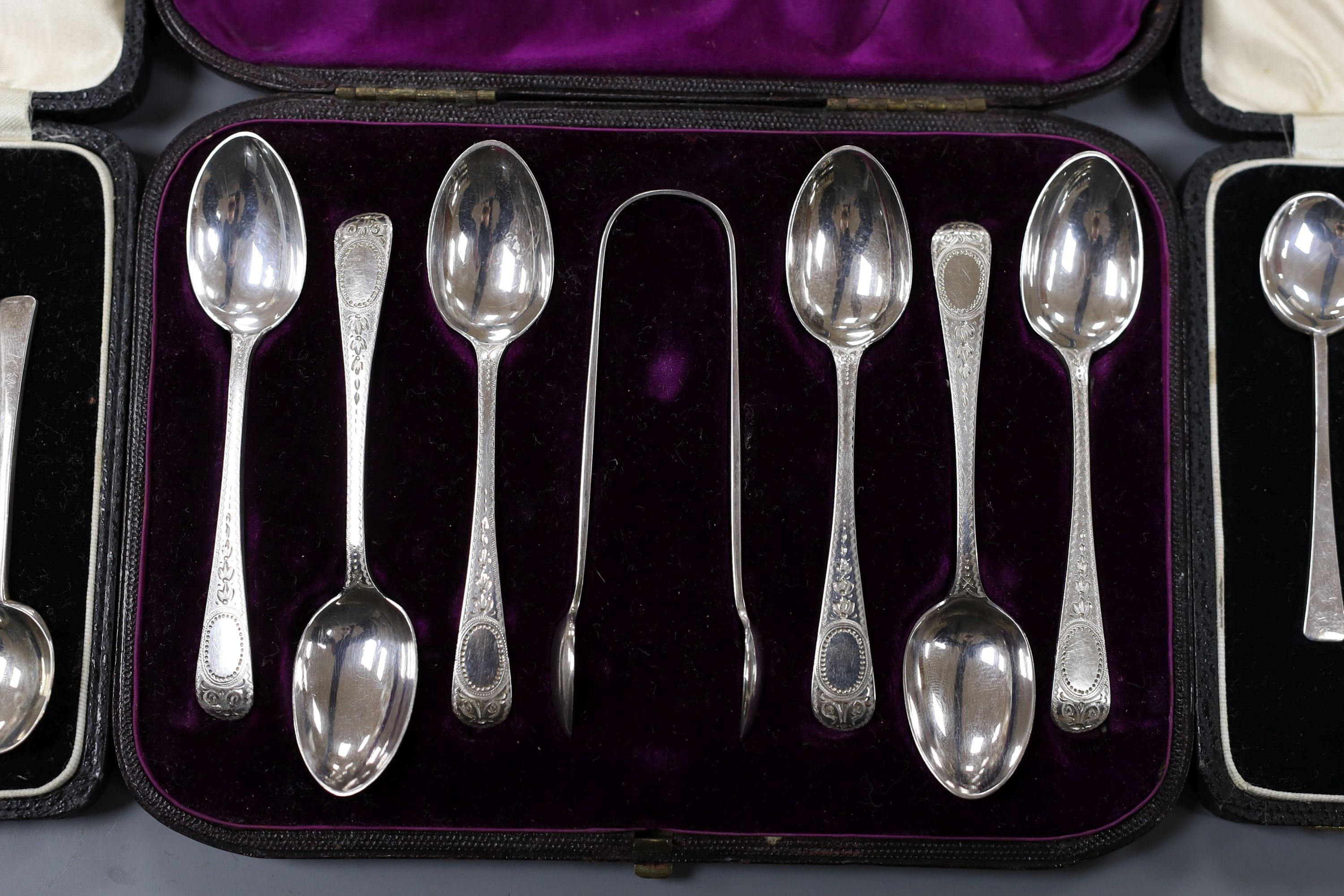 Two cased sets of six silver coffee spoons, Birmingham and a cased set of six engraved silver teaspoons with tongs, London, 1878, 5oz.